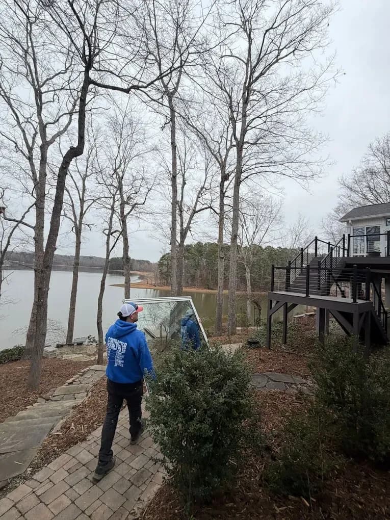 Clemmons workers carrying window pane to house